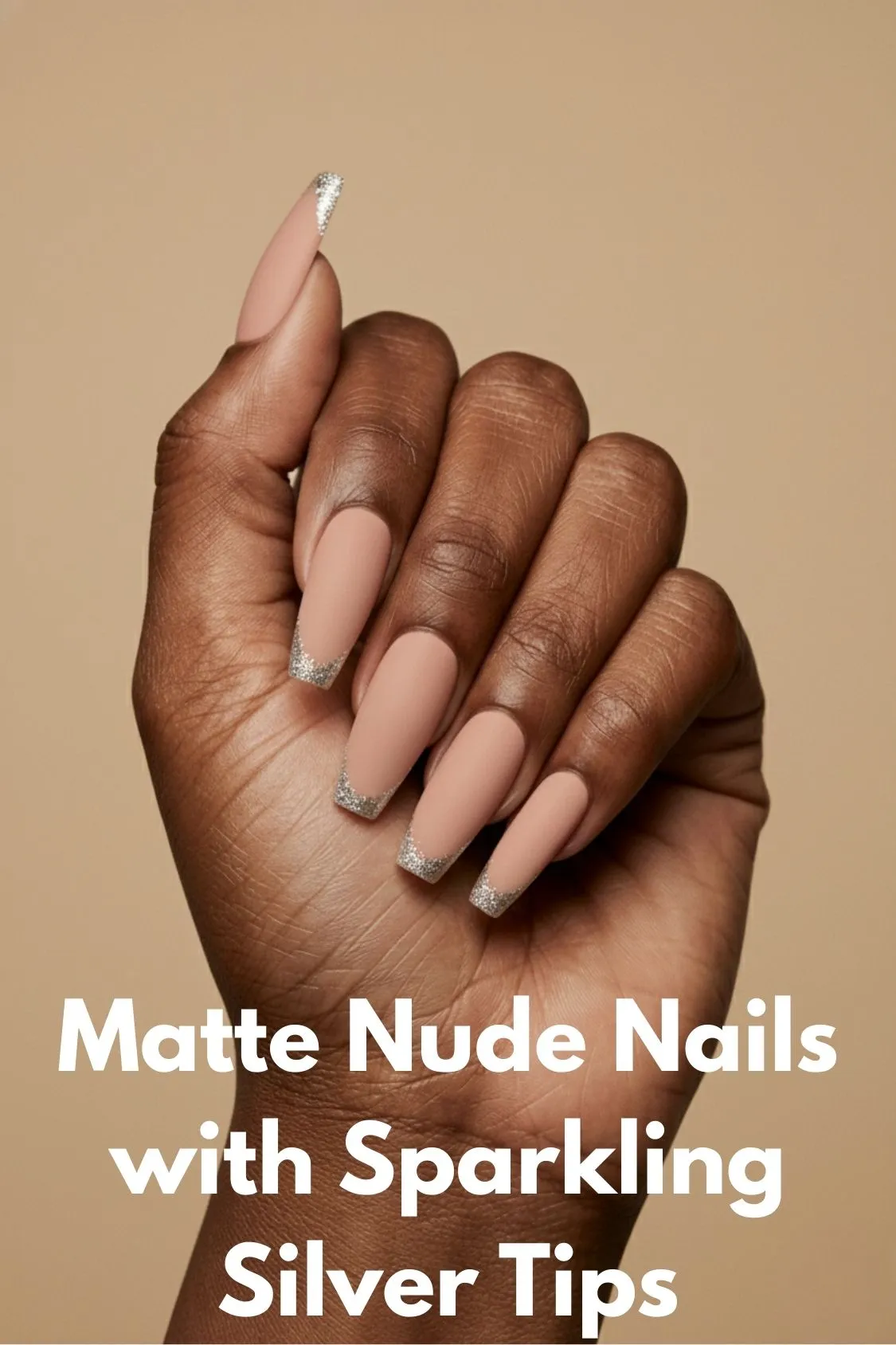 A hand showing short, square acrylic nails with a matte nude base color and sparkling silver glitter tips.